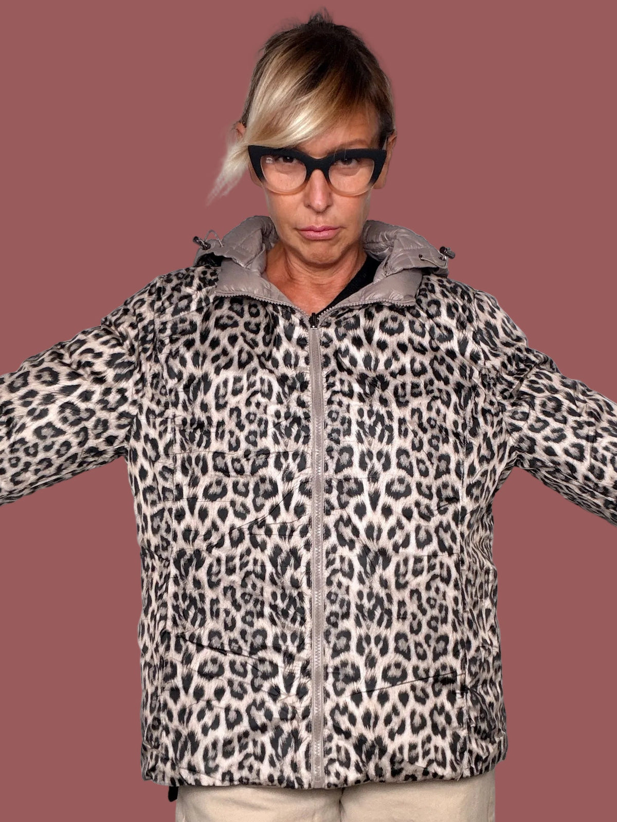 Piumino reversibile con lato stampa leopardo e cappuccio, indossato, vista frontale con braccia aperte