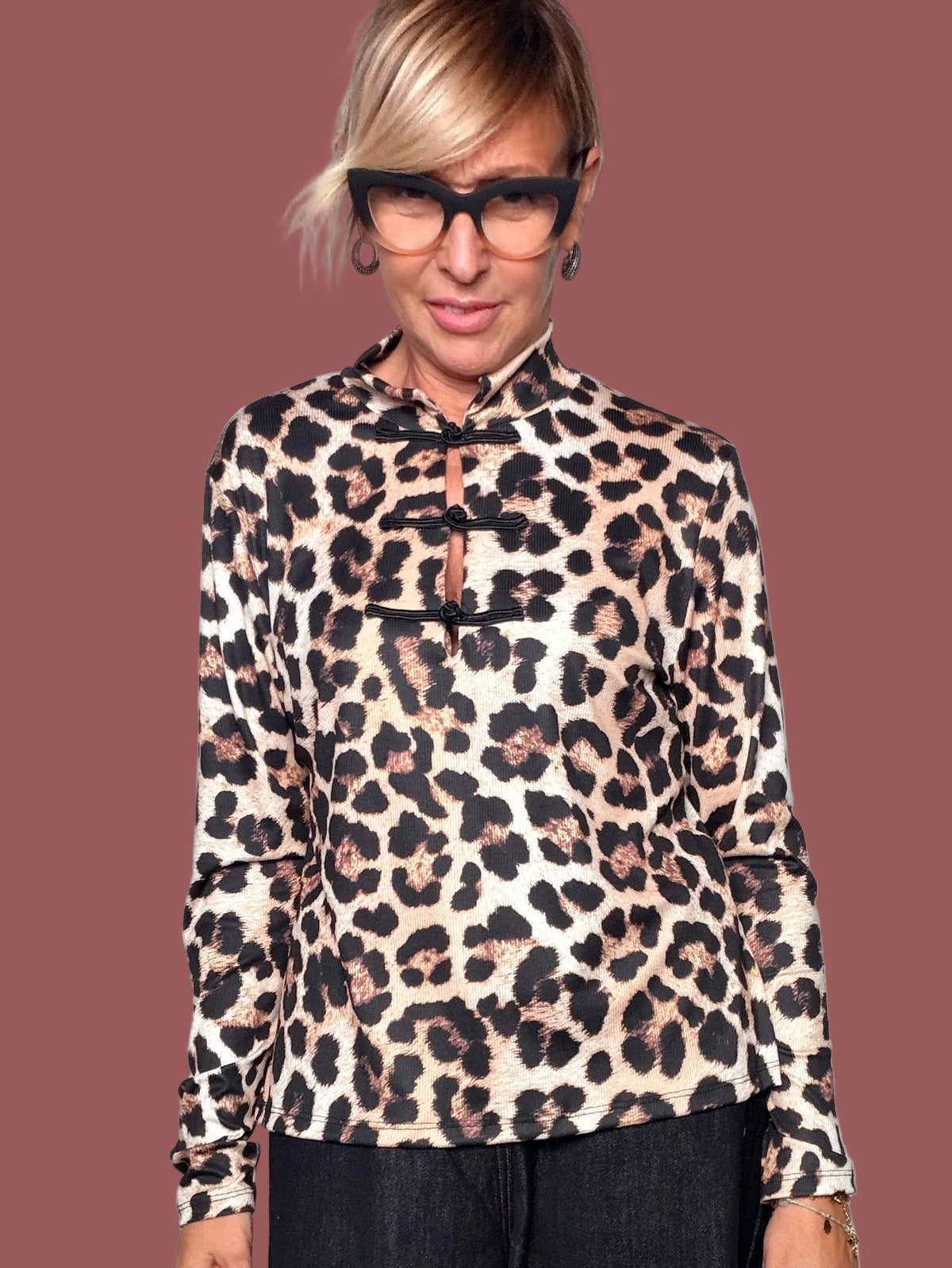 Dettaglio della maglia animalier con collo alto e chiusure decorative nere sul davanti