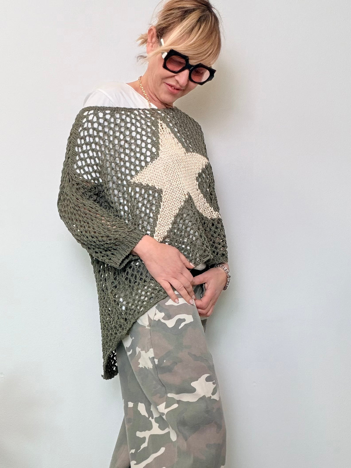 Maglia oversize a rete traforata marrone con stella panna centrale.