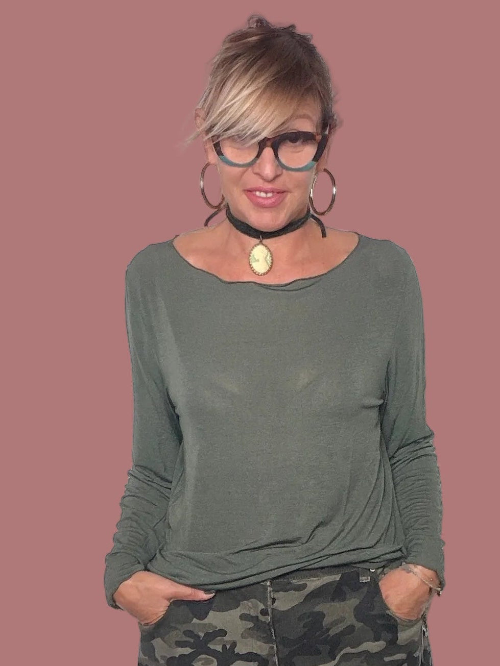 Maglia verde indossata con pantaloni camouflage
