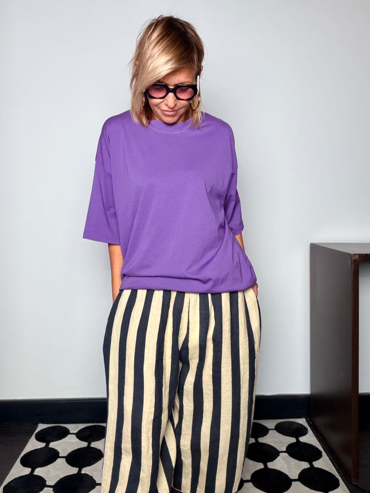 T-shirt oversize collo alto viola abbinata a pantalone a righe