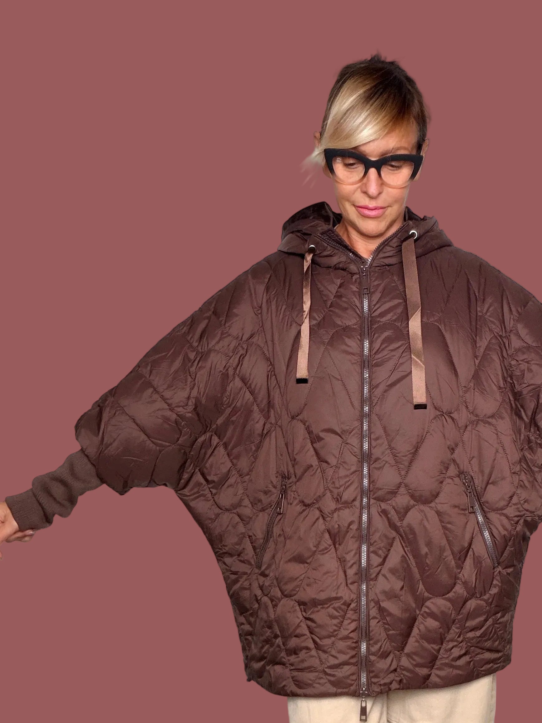 Piumino oversize imbottito a rombi marrone con cappuccio e chiusura zip, indossato davanti