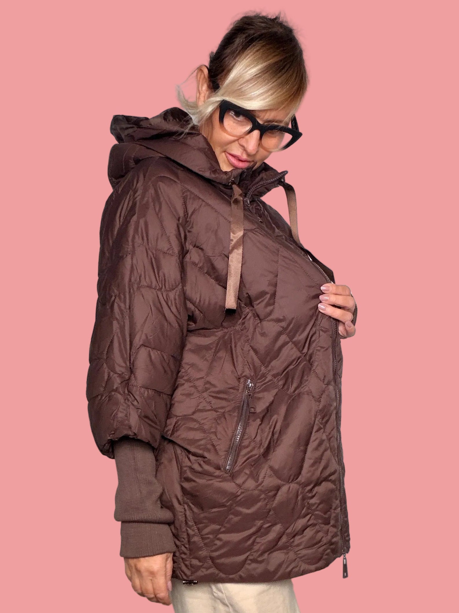 Piumino oversize imbottito a rombi marrone con cappuccio e laccio tirolese, vista frontale con maniche ampie