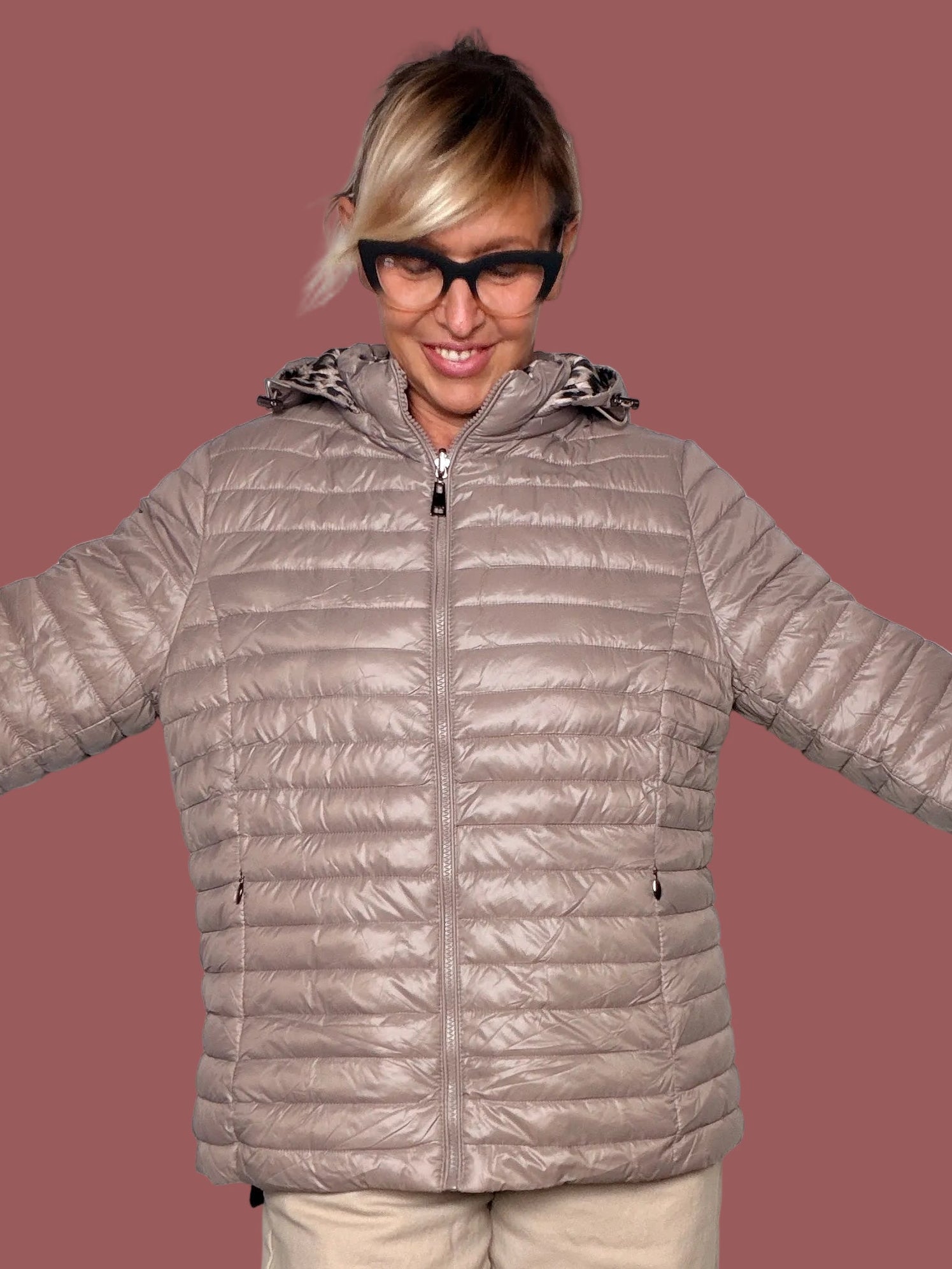 Piumino reversibile taupe con cappuccio e zip, indossato, vista frontale con braccia aperte