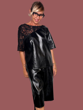 Bermuda ecopelle nero a gamba ampia con coulisse in vita, indossato con maglia coordinata, vista frontale
