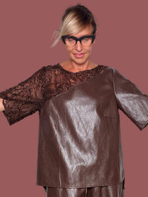 Maglia cubetto ecopelle moro con spalla e manica in pizzo fiorato, indossata con bermuda coordinato, vista frontale con braccia aperte