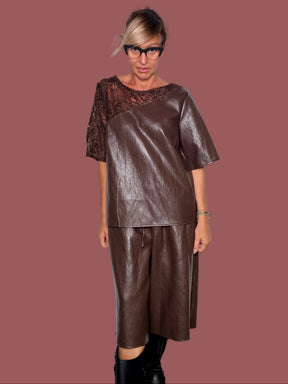 Bermuda ecopelle moro a gamba ampia con coulisse in vita, indossato con maglia coordinata, vista frontale