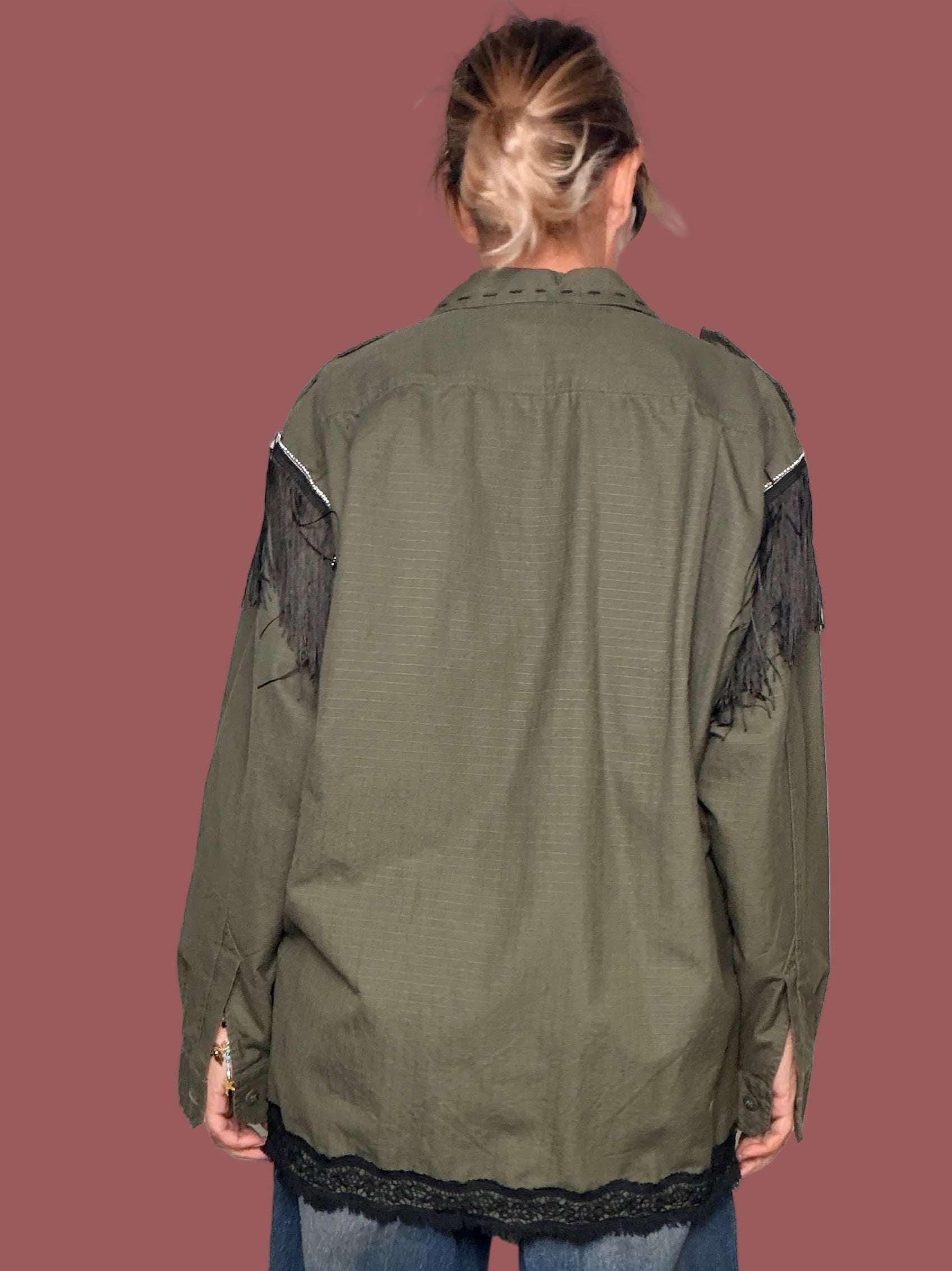 Giacca militare verde oliva con frangie nere sulle spalle e pizzo nero sul fondo, vista posteriore