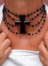 Girocollo a più giri di perline nere con croce nera, indossato su camicia bianca, vista frontale