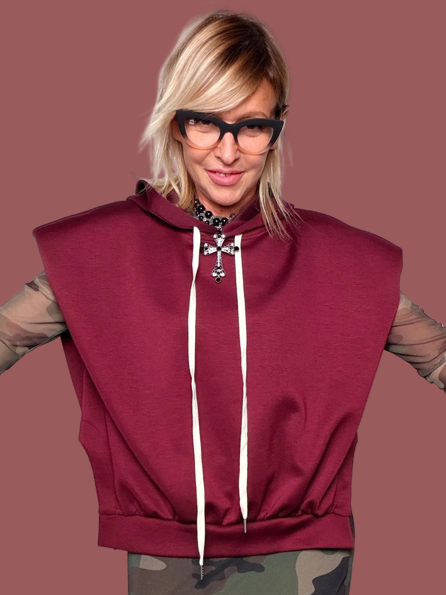 Felpa con cappuccio melanzana senza maniche con coulisse bianche, portata sopra top in tulle camouflage e gonna coordinata, vista frontale
