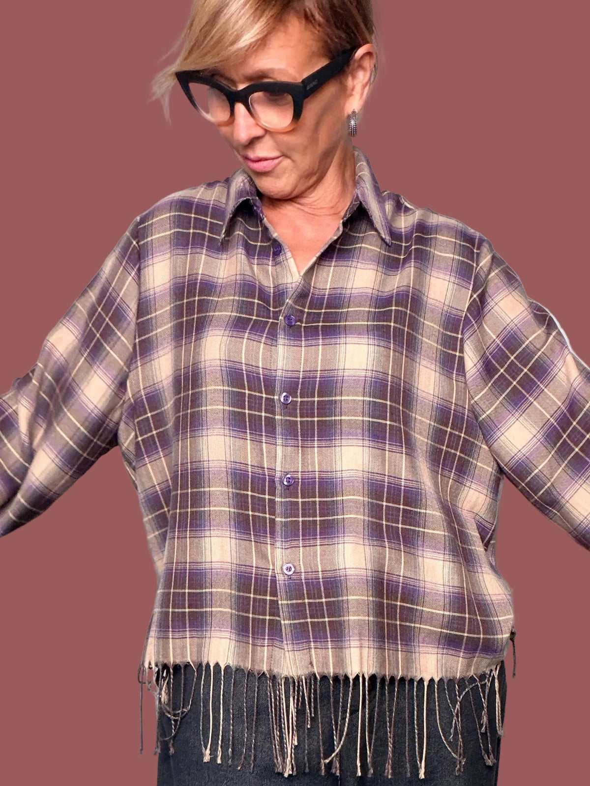 Camicia a quadri beige e viola a manica lunga con frange decorative indossata con jeans scuri