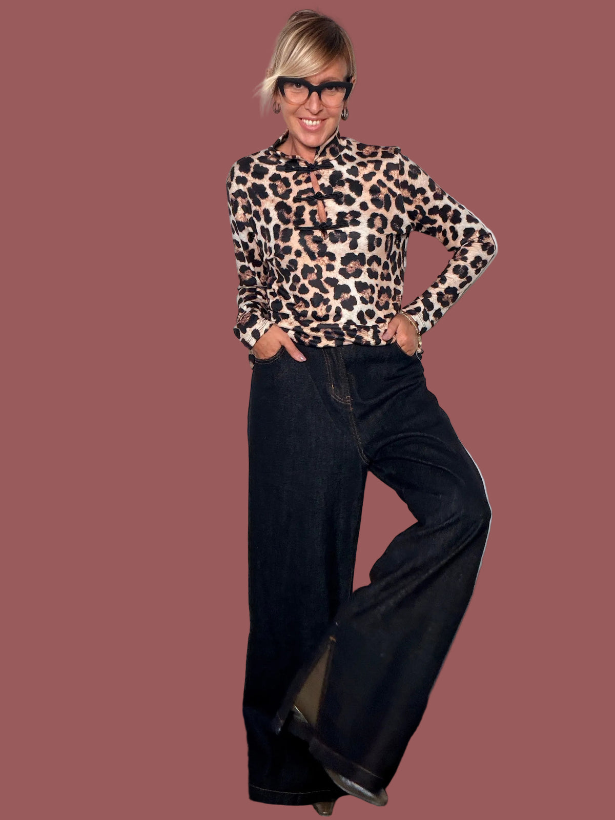 Dettaglio di jeans wide leg blu scuro con tasche laterali e zip al fondo, indossato con stivaletto
