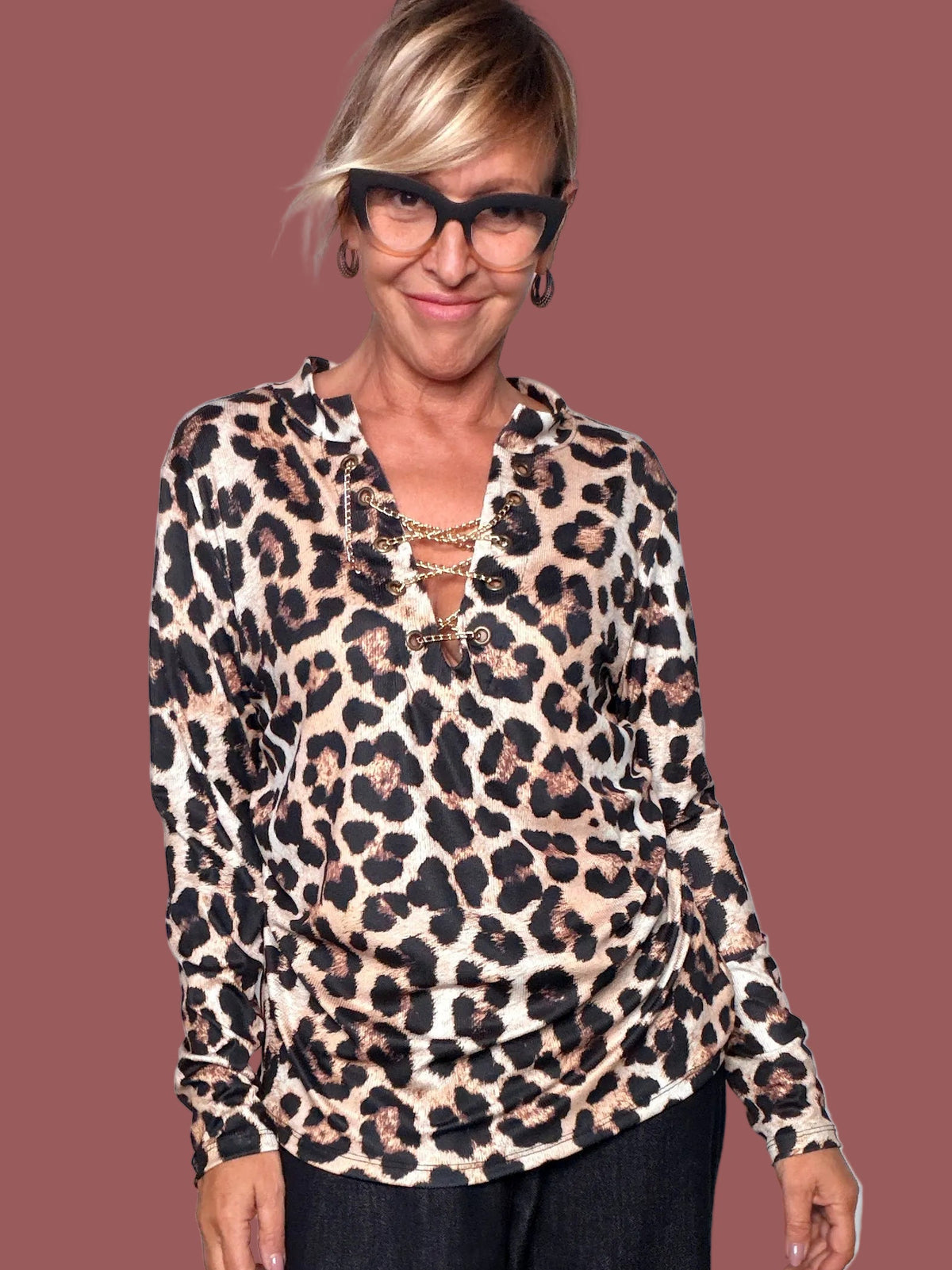 Dettaglio della maglia animalier beige e nera con catene decorative sul davanti