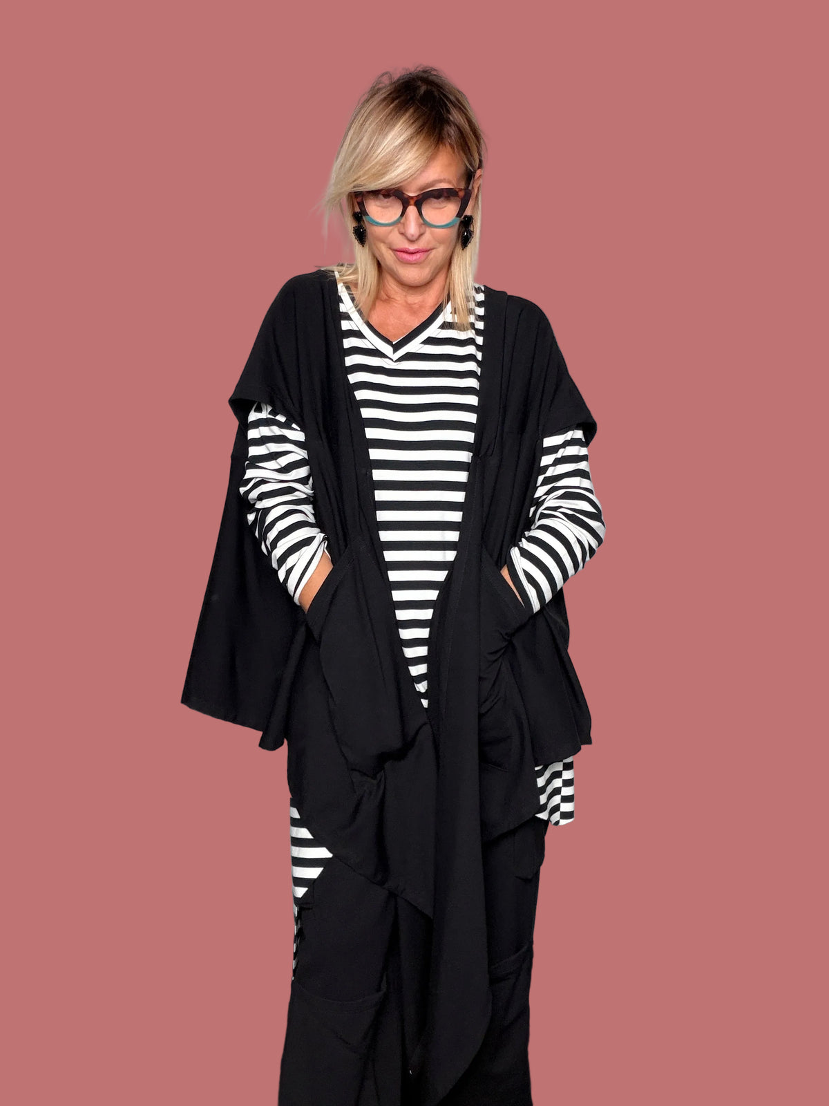 Gilet cardigan lungo nero asimmetrico abbinato a maglia a righe, vista frontale