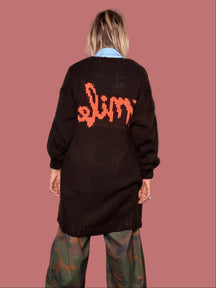 Cardigan lungo marrone, dettaglio scritta arancione sulla schiena