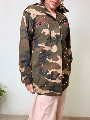 Giacca oversize camouflage verde militare con perle applicate e spille ciliegie rosse.