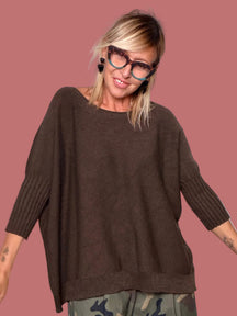 Maglione oversize moro abbinato a pantalone camouflage, vista frontale con braccia aperte
