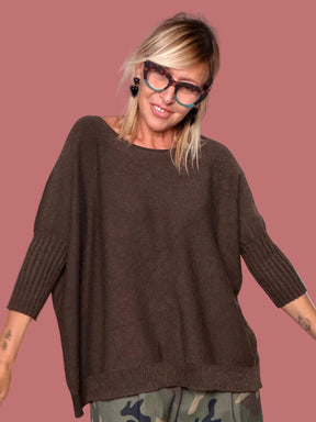 Maglione oversize moro abbinato a pantalone camouflage, vista frontale con braccia aperte