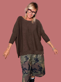 Bermuda fantasia camouflage indossato con maglione marrone, vista laterale
