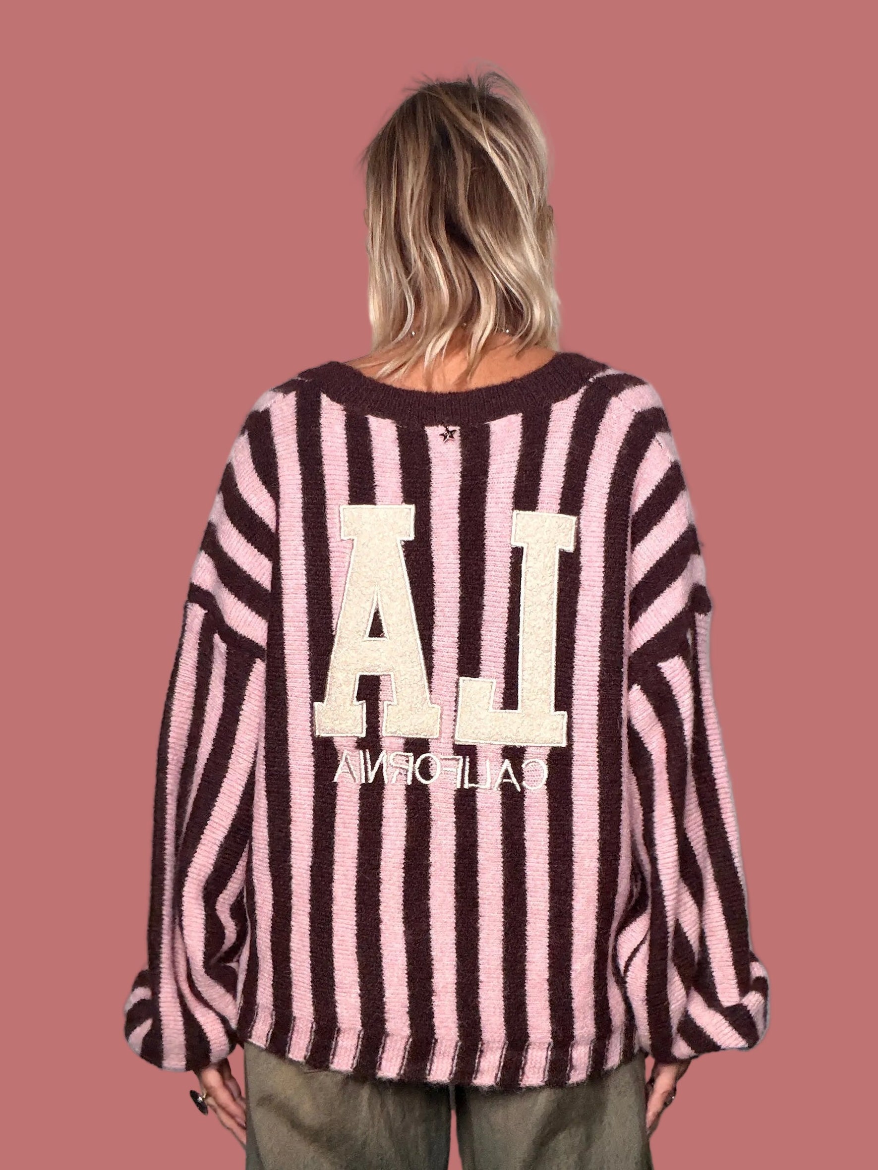 Cardigan Souvenir a righe rosa e scure indossato con pantaloni ampi
