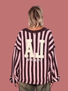 Cardigan Souvenir a righe rosa e scure indossato con pantaloni ampi