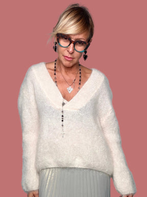 Maglia Souvenir color panna con scollo a V e maniche lunghe, indossata con gonna plissé
