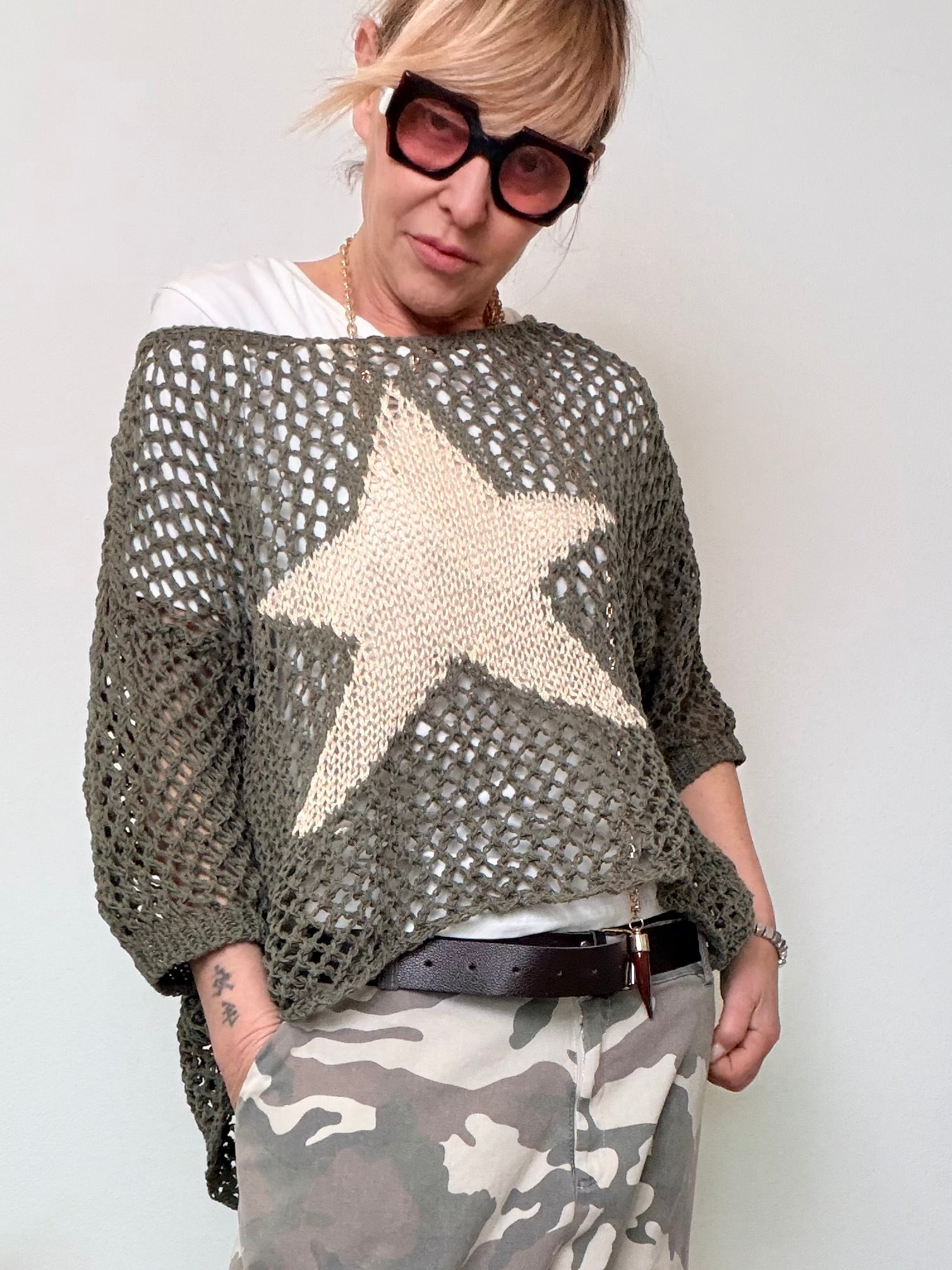 Maglia oversize a rete traforata marrone con stella panna centrale.