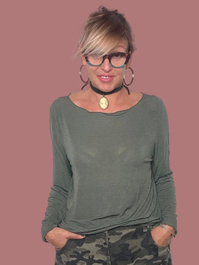 Maglia verde indossata con pantaloni camouflage