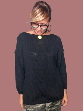 Maglia nera con scollo ampio indossata