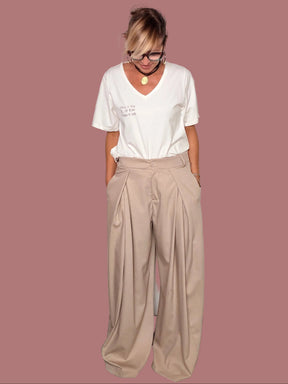 Pantalone beige a gamba ampia indossato con T-shirt bianca