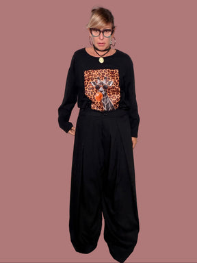 Pantalone palazzo nero con pinces, indossato con maglia stampata