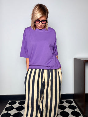T-shirt oversize collo alto viola abbinata a pantalone a righe