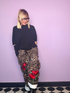 Pantalone animalier con decorazioni floreali rosse