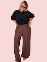 Pantalone plissé marrone cioccolato con t-shirt nera - vista frontale intera