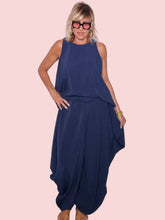 Pantalone harem fluido blu navy con top trapezio coordinato - vista frontale con mano sul fianco