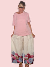 Pantalone palazzo lino latte con bordo floreale - vista frontale con t-shirt rosa
