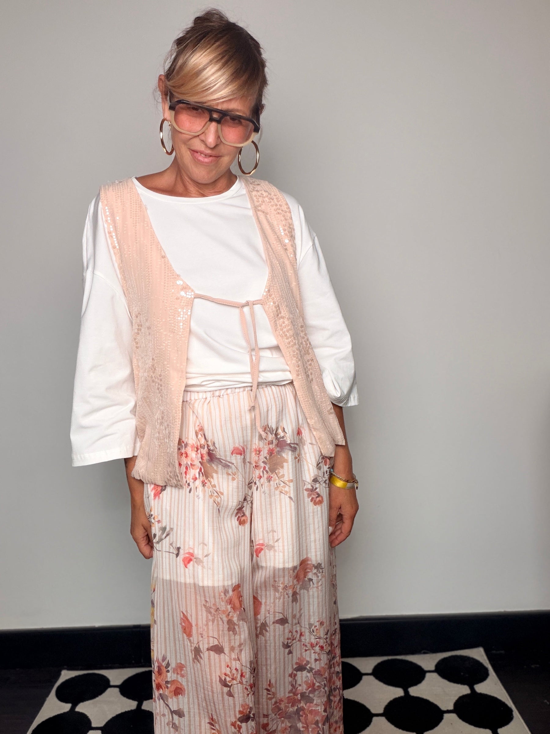 Pantalone palazzo plissettato floreale - vista frontale con gilet pizzo cipria