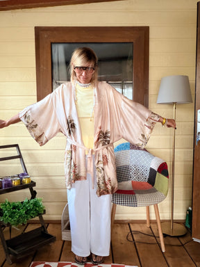 Kimono maxi satinato rosa cipria stampa tropicale - vista frontale aperto con cintura fiocco, pantalone bianco e top giallo