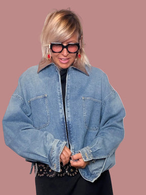 Giacca denim cropped - vista laterale con abito midi nero e cintura borchiata