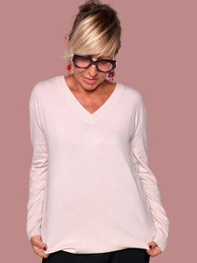 Maglia oversize scollo V primo peso rosa cipria - vista frontale con pantalone nero wide leg