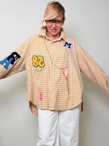 Camicia over a quadretti con patch decorative