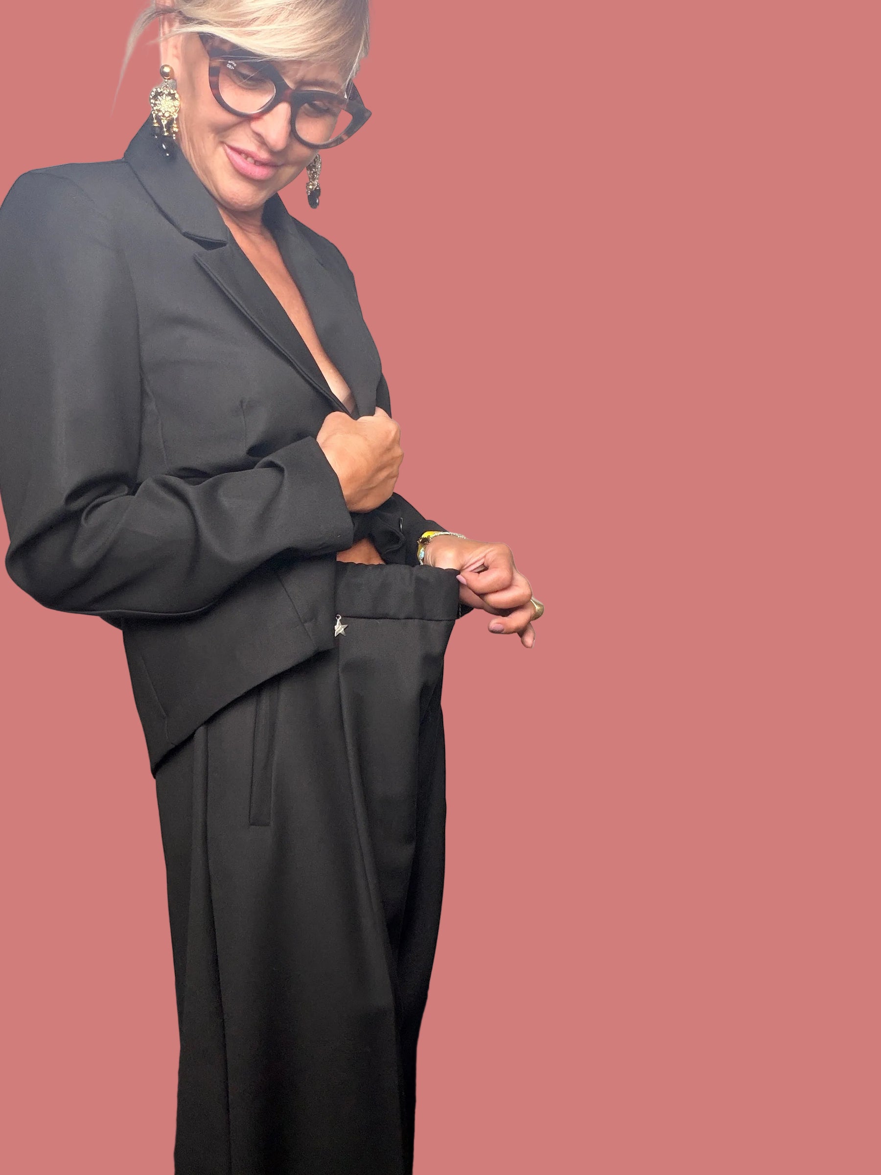 Dettaglio del pantalone nero a gamba ampia con fascia in vita