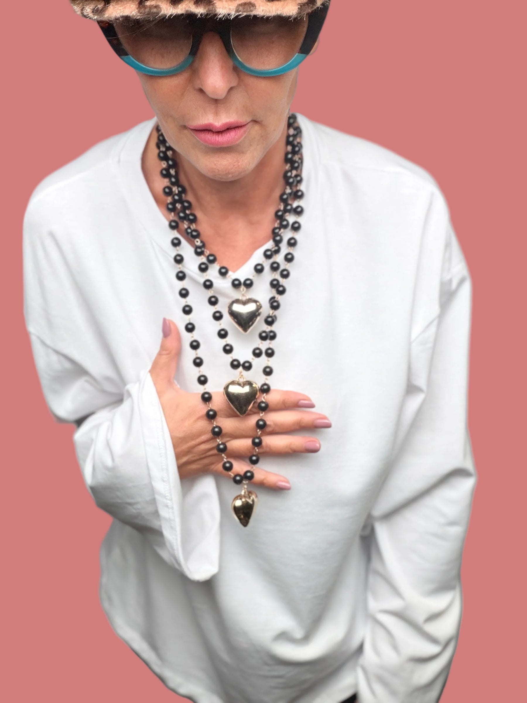 Collana multistrato con perle nere e pendenti a cuore indossata