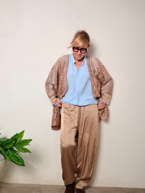 Giacca lunga dallo stile raffinato realizzata in pizzo trasparente con dettagli in satin