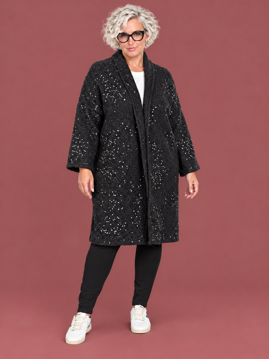 Cappottino bouclé aperto con dettagli luminosi — modella curvy